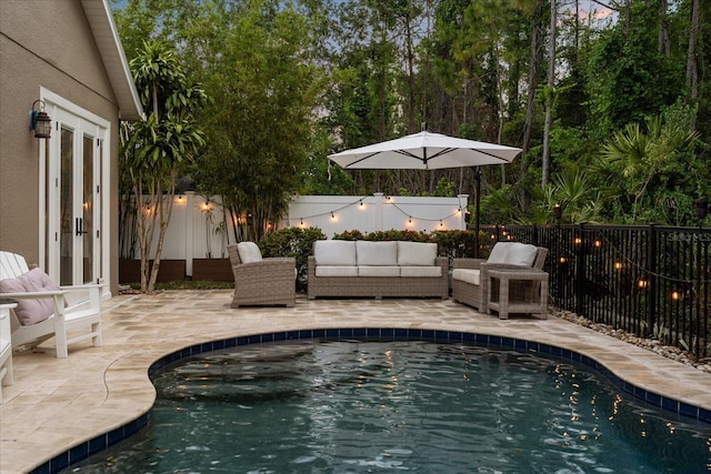 view of pool featuring french doors, a fenced backyard, a patio, and an outdoor hangout area