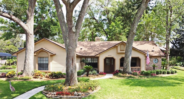 view of front facade featuring a front lawn, a porch, and a chimney