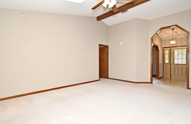 spare room featuring light carpet, arched walkways, ceiling fan, and baseboards