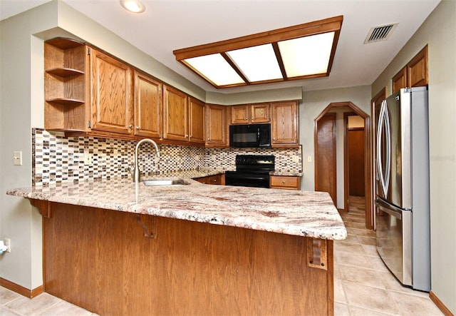 kitchen featuring black appliances, a sink, a peninsula, open shelves, and tasteful backsplash