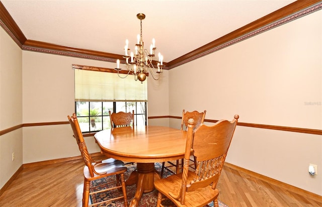 dining area featuring a chandelier, light wood finished floors, baseboards, and crown molding