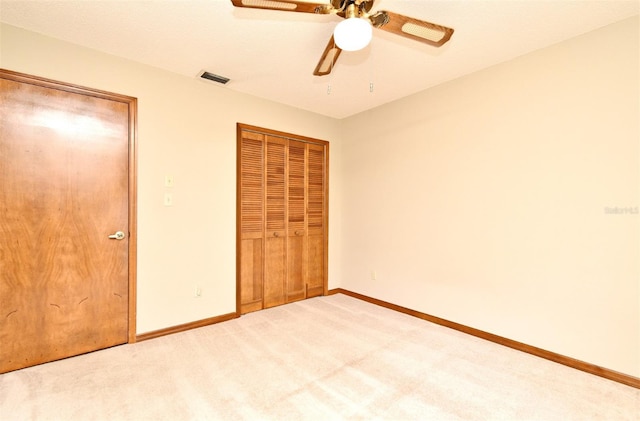 unfurnished bedroom with carpet, baseboards, a closet, and ceiling fan
