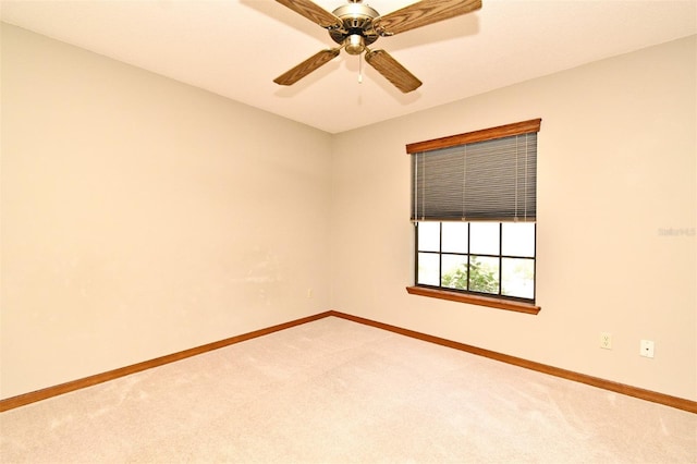 spare room with carpet floors, baseboards, and ceiling fan