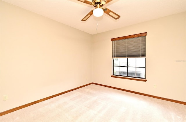 empty room with baseboards, light colored carpet, and a ceiling fan