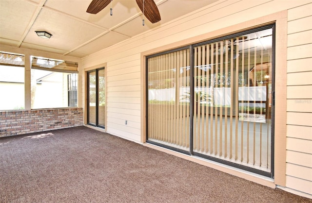 unfurnished sunroom with ceiling fan