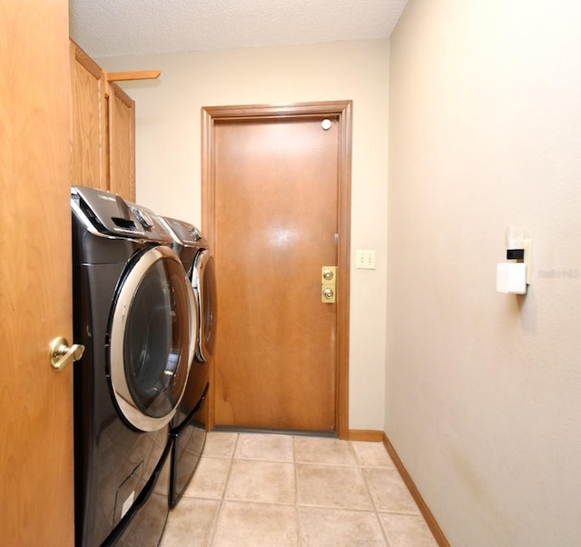 clothes washing area with separate washer and dryer, cabinet space, light tile patterned floors, and baseboards