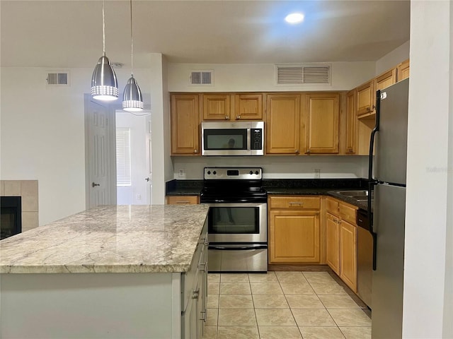 315 Lakepointe Dr Unit 101, Altamonte Springs, FL 32701 - kitchen with stainless steel appliances, light tile patterned flooring, decorative light fixtures, light stone countertops, and a center island