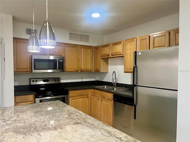 315 Lakepointe Dr Unit 101, Altamonte Springs, FL 32701 - kitchen featuring appliances with stainless steel finishes, a sink, hanging light fixtures, dark stone countertops, and recessed lighting
