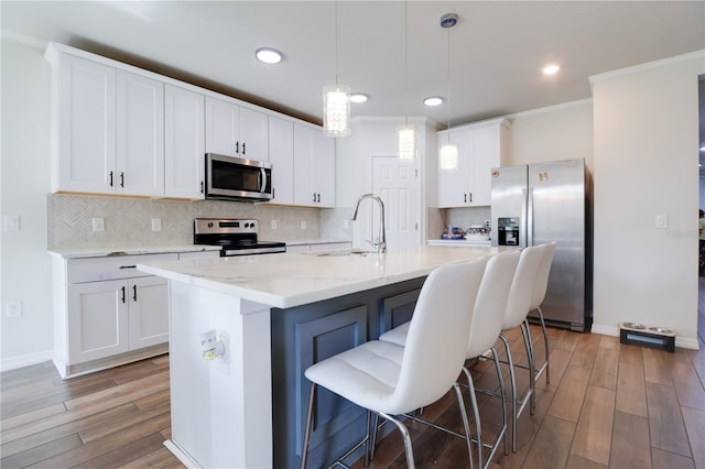 719 Tortugas St, Haines City, FL 33844 - kitchen with appliances with stainless steel finishes, a sink, light wood-style flooring, decorative backsplash, and recessed lighting