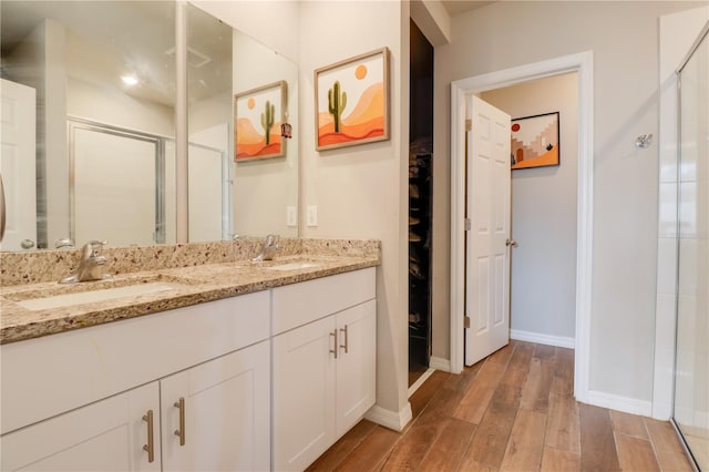 719 Tortugas St, Haines City, FL 33844 - bathroom with wood finished floors, a shower stall, baseboards, and double vanity