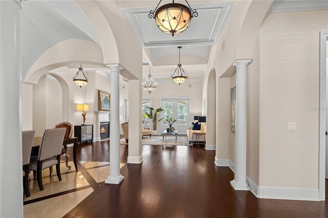 5909 Oxford Moor Blvd, Windermere, FL 34786 - foyer featuring a lit fireplace, arched walkways, ornate columns, hardwood / wood-style flooring, and ornamental molding