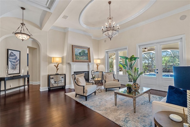 5909 Oxford Moor Blvd, Windermere, FL 34786 - living area featuring french doors, a chandelier, dark wood-style flooring, a glass covered fireplace, and crown molding
