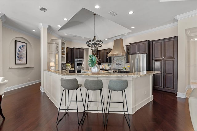 5909 Oxford Moor Blvd, Windermere, FL 34786 - kitchen with stainless steel appliances, custom range hood, a peninsula, a breakfast bar area, and recessed lighting