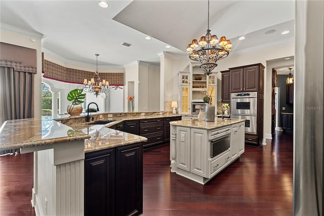5909 Oxford Moor Blvd, Windermere, FL 34786 - kitchen featuring a chandelier, a large island with sink, a sink, double oven, and dark wood finished floors