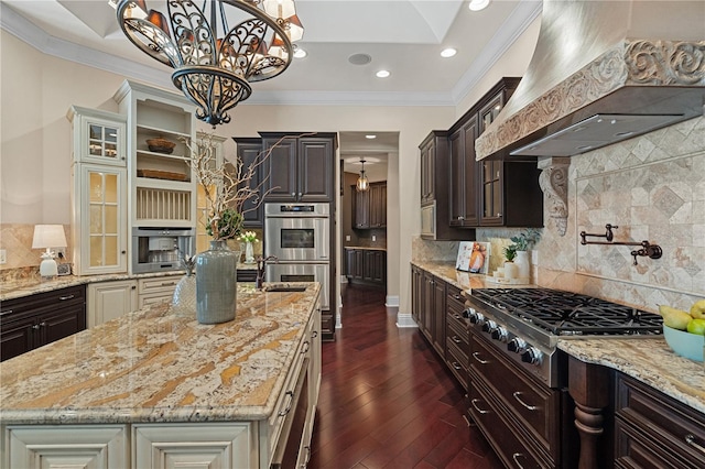 5909 Oxford Moor Blvd, Windermere, FL 34786 - kitchen with custom range hood, stainless steel appliances, crown molding, light stone counters, and decorative backsplash