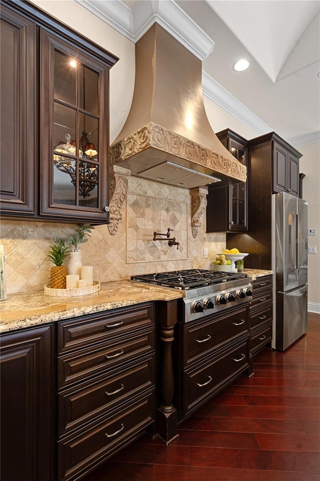 5909 Oxford Moor Blvd, Windermere, FL 34786 - kitchen with stainless steel appliances, custom exhaust hood, glass insert cabinets, crown molding, and dark brown cabinetry