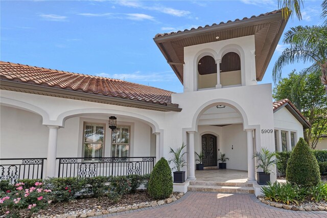 5909 Oxford Moor Blvd, Windermere, FL 34786 - entrance to property with covered porch, stucco siding, and a tile roof