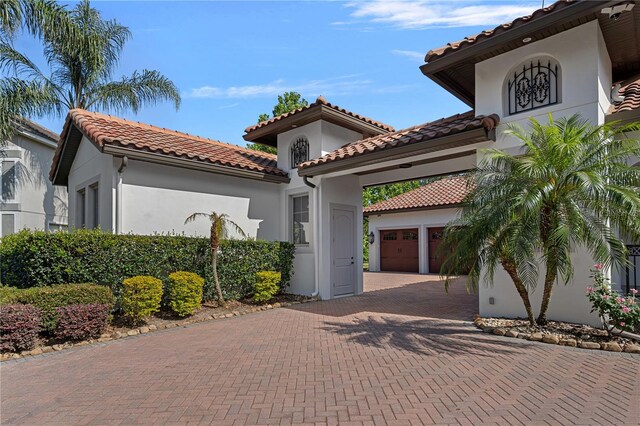 5909 Oxford Moor Blvd, Windermere, FL 34786 - mediterranean / spanish home with a tile roof, decorative driveway, and stucco siding