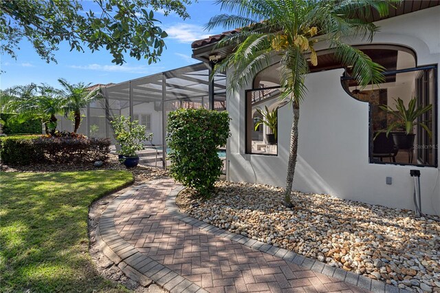 5909 Oxford Moor Blvd, Windermere, FL 34786 - view of side of property with stucco siding, a lanai, and a lawn