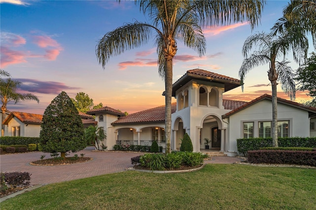 5909 Oxford Moor Blvd, Windermere, FL 34786 - mediterranean / spanish home featuring a tile roof, curved driveway, stucco siding, and a yard