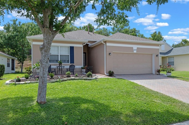 ranch-style home with a garage, stucco siding, driveway, and a front yard