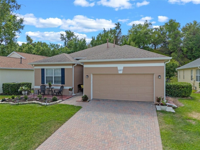 single story home with stucco siding, a front yard, an attached garage, decorative driveway, and a shingled roof