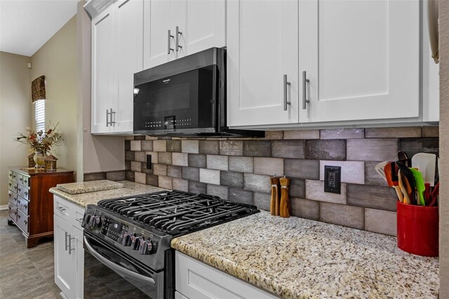 kitchen with black appliances, light stone countertops, white cabinets, and backsplash