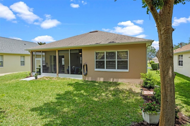 back of house featuring a sunroom, a yard, and stucco siding