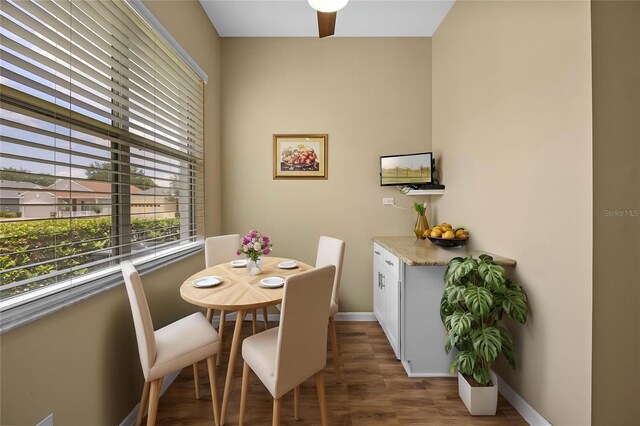 dining area with dark wood-style flooring and baseboards