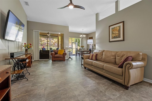 living room featuring ceiling fan, a chandelier, and baseboards