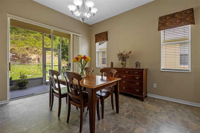 dining area with a chandelier and baseboards