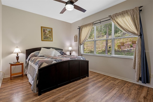bedroom with wood finished floors, baseboards, and a ceiling fan