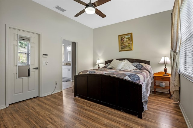 bedroom featuring wood finished floors, baseboards, and connected bathroom