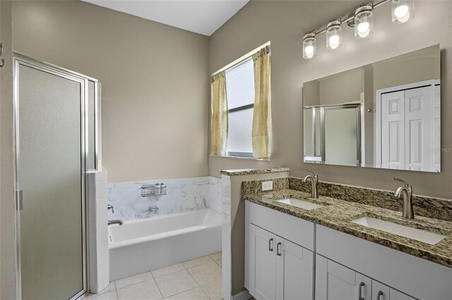 bathroom featuring a shower stall, a bath, double vanity, and tile patterned flooring