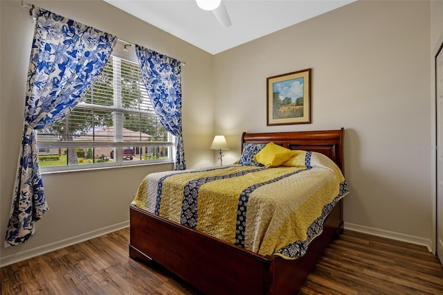 bedroom featuring baseboards, wood finished floors, and a ceiling fan