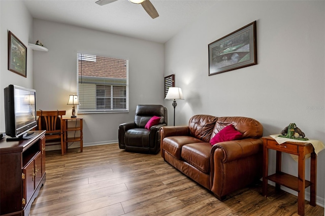 living room featuring wood finished floors, a ceiling fan, and baseboards