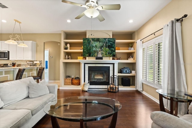 1428 Lucky Pennie Way, Apopka, FL 32712 - living area with dark wood-style floors, a tiled fireplace, baseboards, a ceiling fan, and recessed lighting
