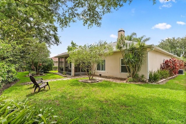 1428 Lucky Pennie Way, Apopka, FL 32712 - rear view of house with stucco siding, a sunroom, a chimney, and a lawn