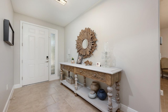 entryway with baseboards and light tile patterned floors