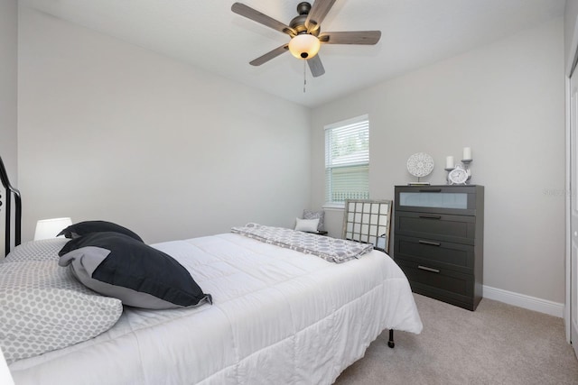 bedroom with light carpet, baseboards, and ceiling fan