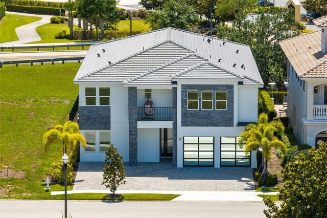 300 Muirfield Loop, Reunion, FL 34747 - view of front of home with a garage, stucco siding, driveway, and a balcony