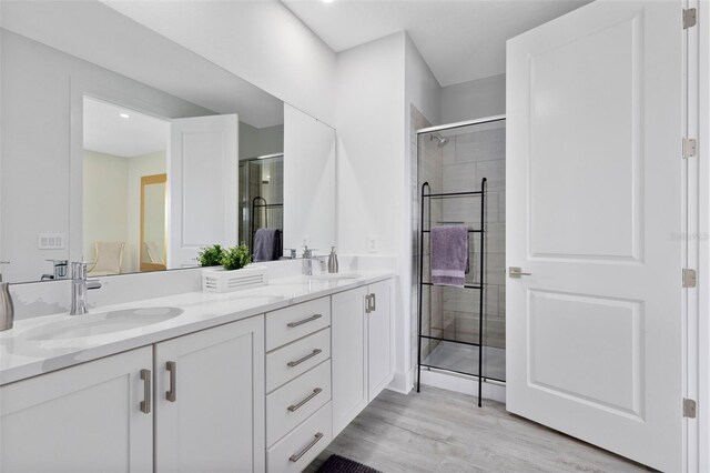 300 Muirfield Loop, Reunion, FL 34747 - bathroom with double vanity, tiled shower, and wood finished floors