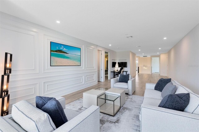 300 Muirfield Loop, Reunion, FL 34747 - living room featuring light wood-style flooring, recessed lighting, and a decorative wall