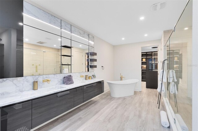 300 Muirfield Loop, Reunion, FL 34747 - full bathroom with a stall shower, tasteful backsplash, double vanity, wood finished floors, and recessed lighting