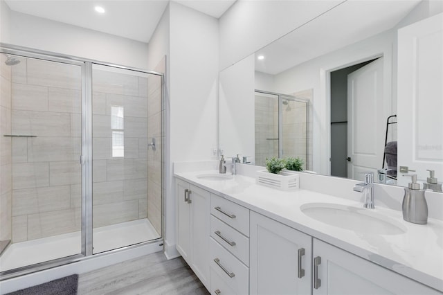 300 Muirfield Loop, Reunion, FL 34747 - bathroom featuring a shower stall, double vanity, wood finished floors, and recessed lighting