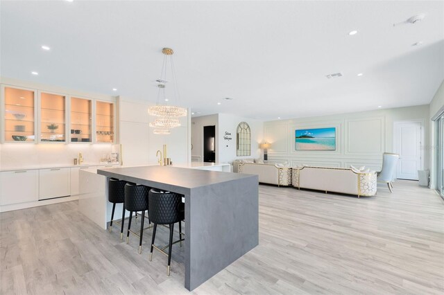 300 Muirfield Loop, Reunion, FL 34747 - kitchen featuring white cabinets, an island with sink, light wood-style flooring, recessed lighting, and modern cabinets