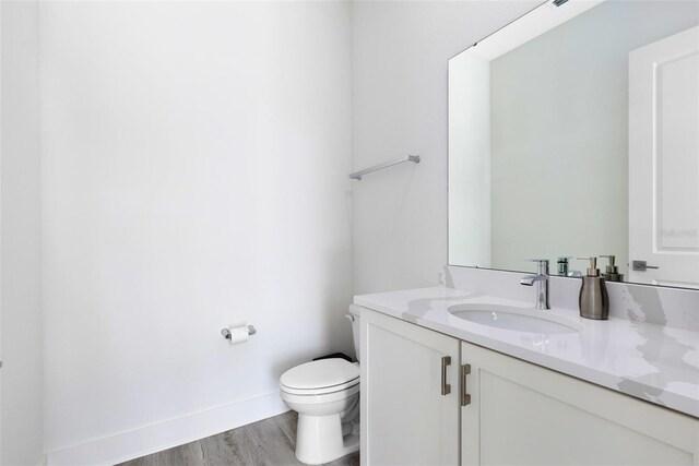 300 Muirfield Loop, Reunion, FL 34747 - half bath featuring vanity, toilet, wood finished floors, and baseboards