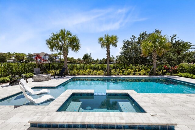 300 Muirfield Loop, Reunion, FL 34747 - view of swimming pool featuring a fire pit, a patio area, fence, and a pool with connected hot tub