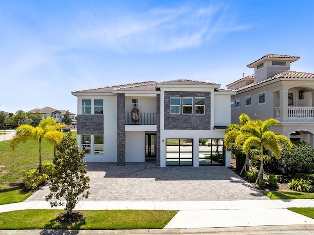 300 Muirfield Loop, Reunion, FL 34747 - view of front facade featuring driveway, stucco siding, a balcony, and a tile roof