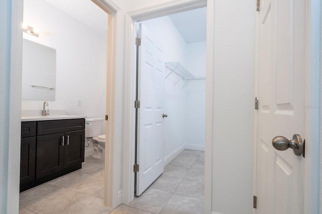 15998 SW 33rd Avenue Rd, Ocala, FL 34473 - bathroom featuring vanity, toilet, a spacious closet, and tile patterned flooring